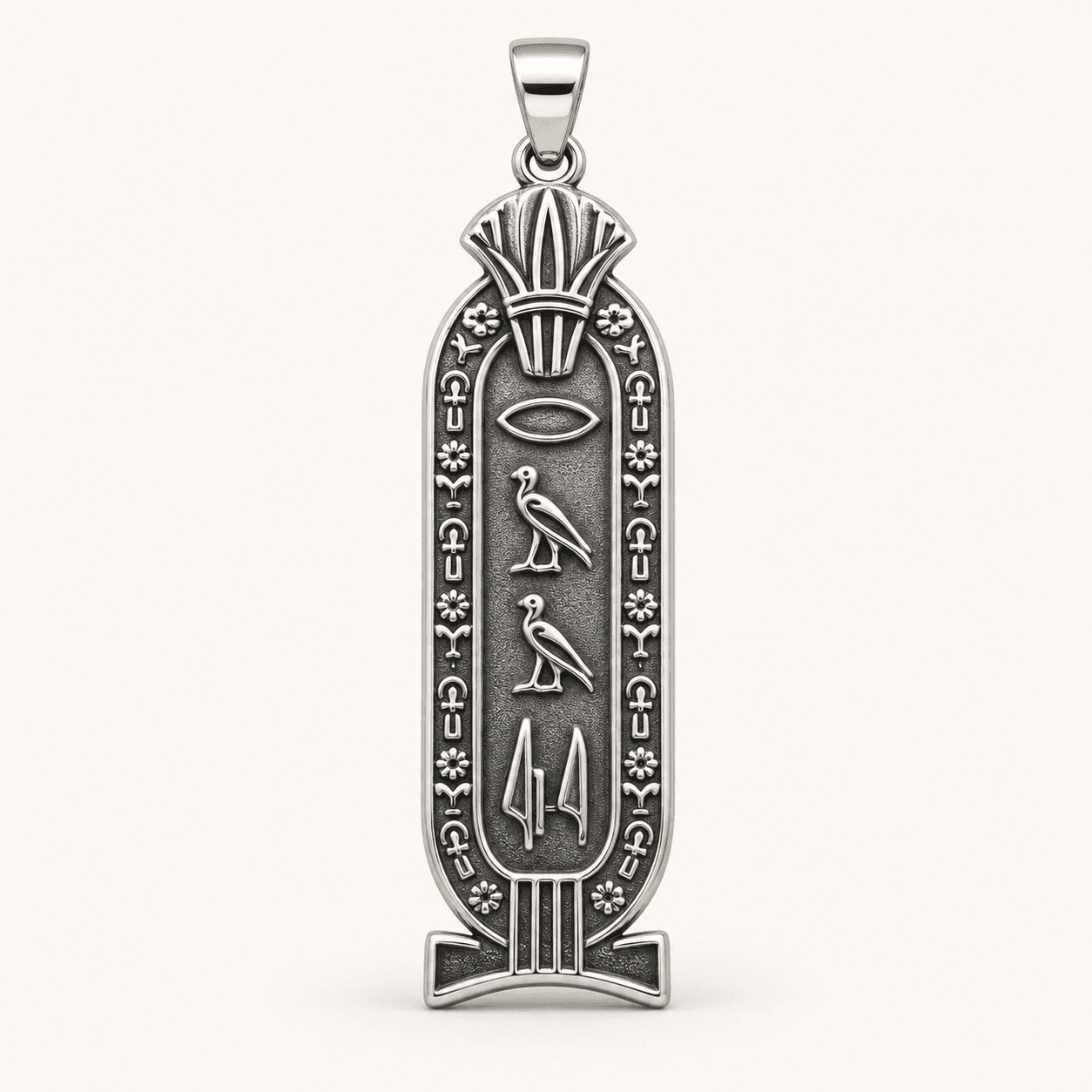 Close detail of a hand-cast gold hieroglyph cartouche pendant